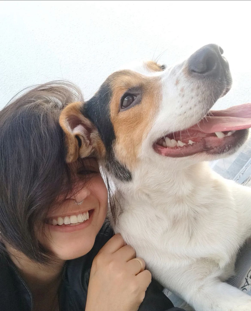 Tia Rebeca sorrindo abraçada com um dos cães do Vida Caninna